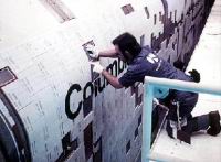 Recoller manuellement les tuiles  d&eacute;t&eacute;rior&eacute;es repr&eacute;sente un travail pr&eacute;cis et fastidieux. Notez le nombre &agrave; modifier sur une zone qui n’est pas pourtant sp&eacute;cialement sensible (les flancs de la navette).