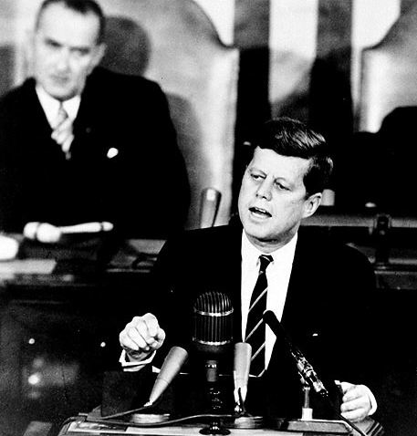 Press&eacute; par les rapports alarmants de la CIA sur le programme spatial sovi&eacute;tique, Kennedy lance le 25 mai 61 la course &agrave; la lune. Son vice-pr&eacute;sident (derri&egrave;re &agrave; gauche), s’il ne para&icirc;t pas convaincu, sait d&eacute;j&agrave; qu’il en tirera gloire et….des subsides pour son &eacute;tat, le Texas (Houston devient le fief de la NASA, cr&eacute;&eacute;e en 1960 par Eisenhower).