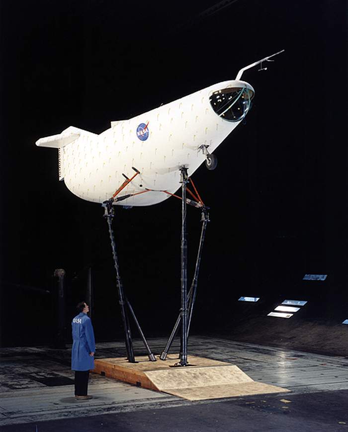 Dans le tunnel a&eacute;rodynamique d’Ames, un technicien regarde avec une certaine surprise l’engin &agrave; tester, muni de ses petits filets de coton. Milt Thompson, le pilote, fera plus d’une dizaine d’heures de tests, en haut de cette baignoire de bois juch&eacute;e sur 3 m&acirc;ts.